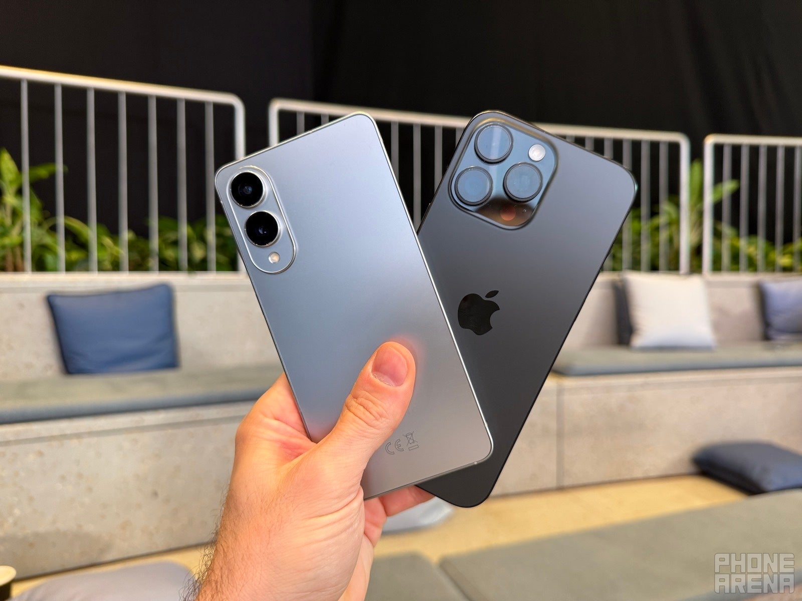 Galaxy S25 Edge and iPhone 16 Pro Max held in hand, backs towards the camera